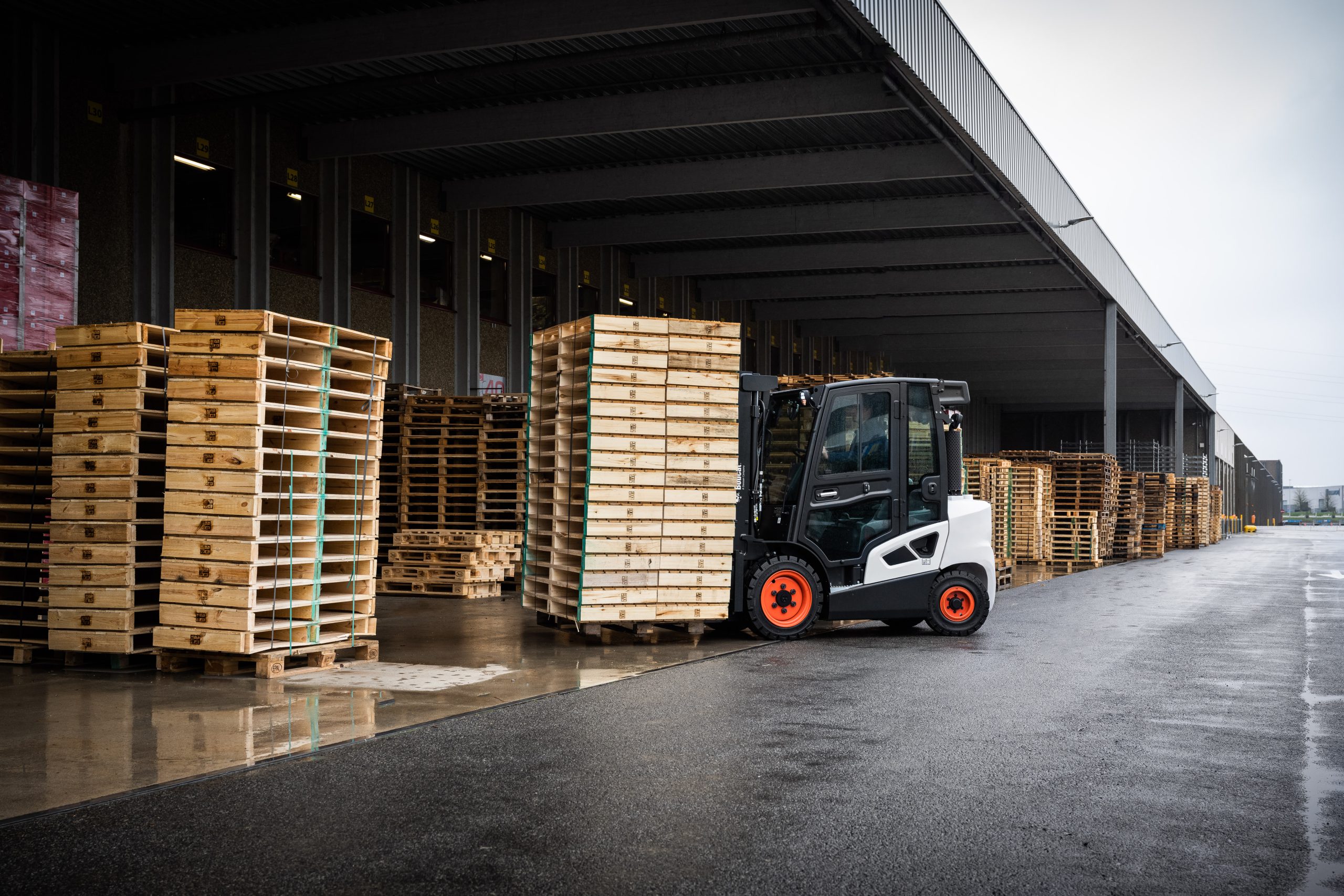 Doosan Bobcat Diesel Counterbalance Forklift Truck lifting a stack of pallets in a warehouse
