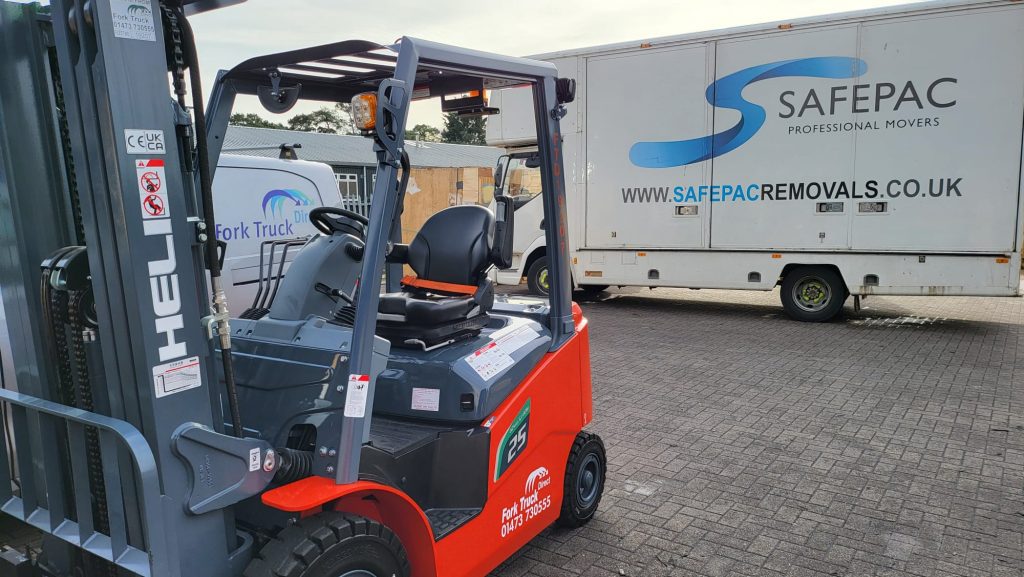 HELI Lithium Counterbalanced Forklift Truck Positioned in front of a SafePac removals van in Mildenhall, Suffolk.